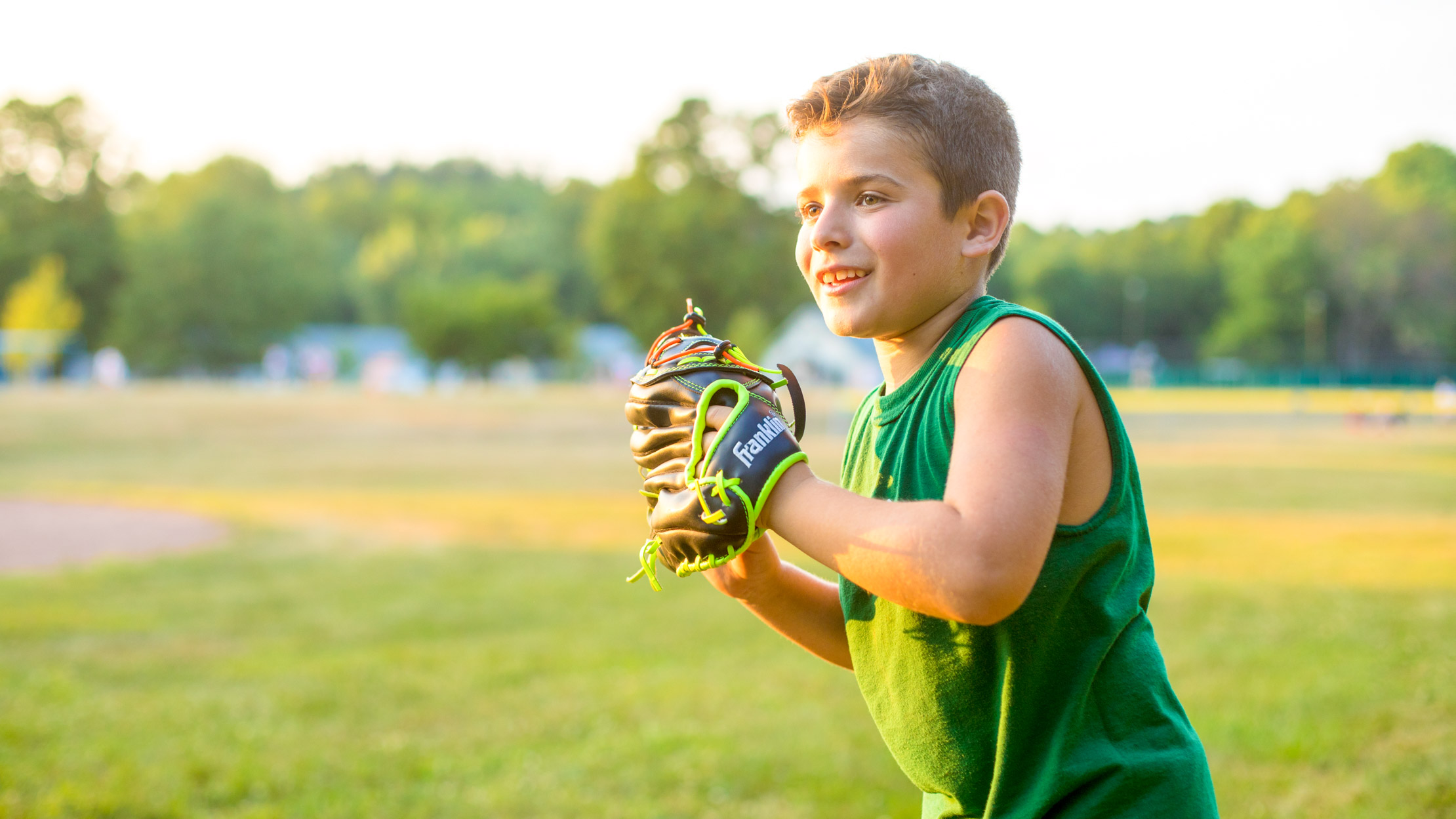 Boy pitches baseball during summer camp game