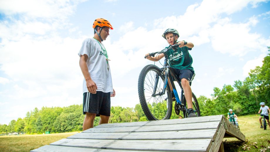 Camper rides mountain bike over bridge obstacle