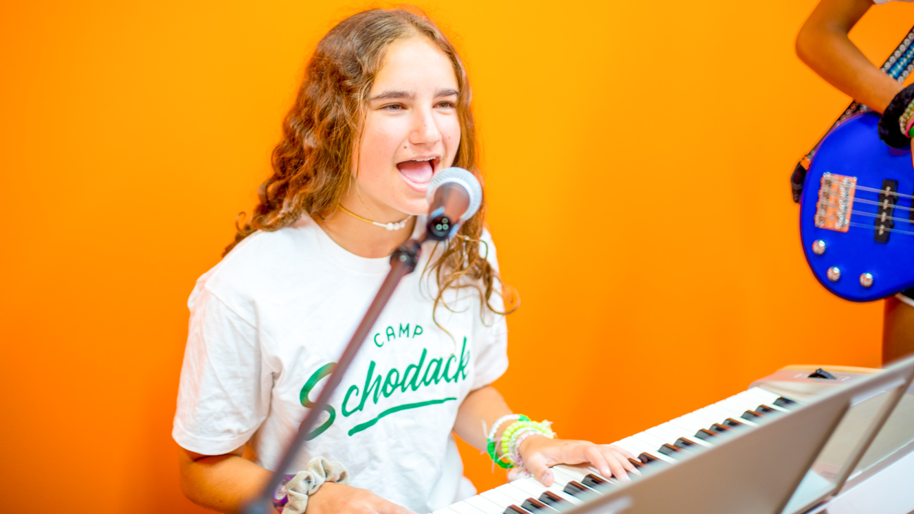 Camper sings while playing piano