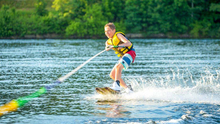 Boy wakeboards at summer camp