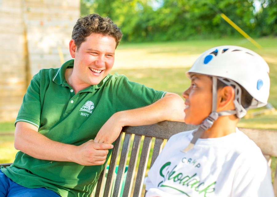 Camp director talks to camper wearing helmet