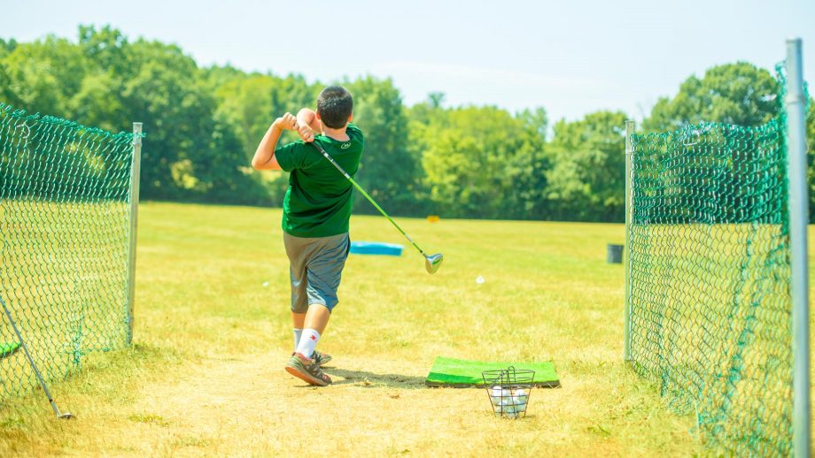 Boy using Camp Schodack golf driving range