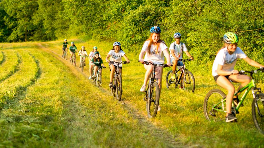 Group of girls mountain bikes through field