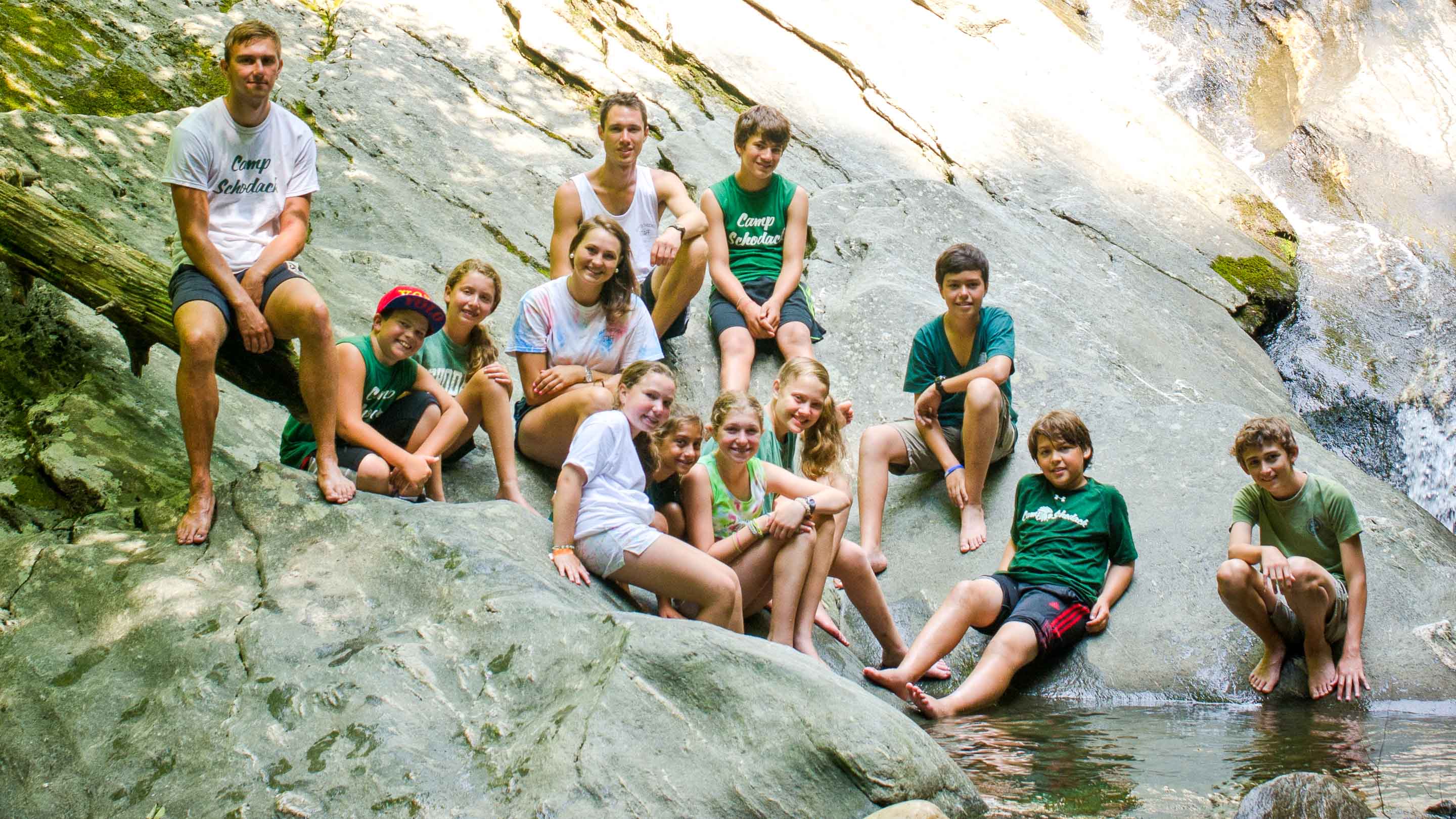 Group of campers sits next to rock pool