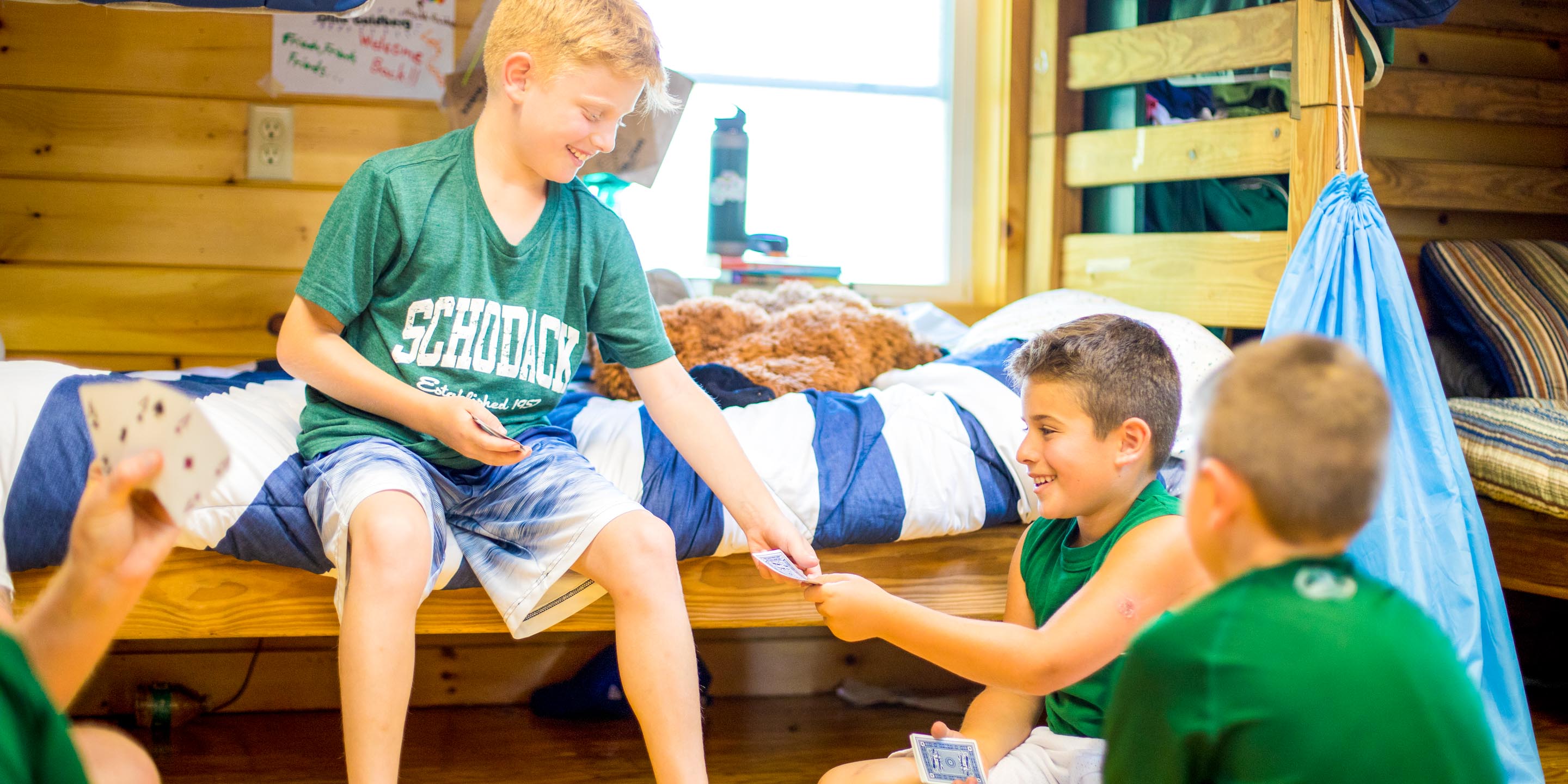 Boys playing cards in their camp cabin