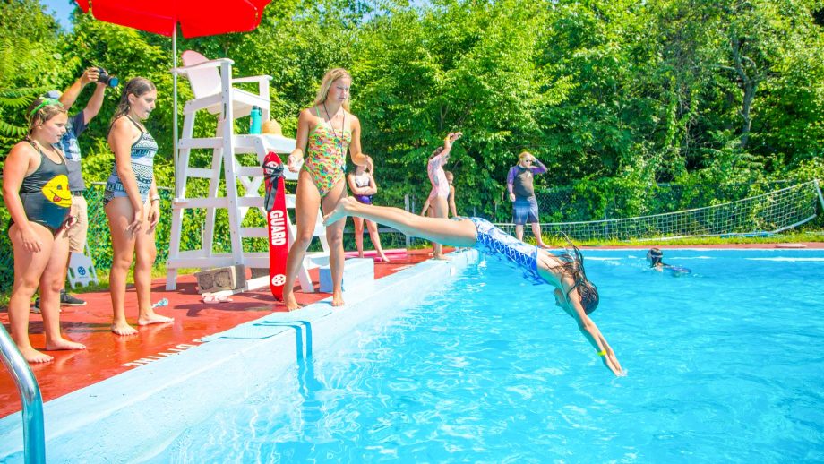 Girl dives into pool at summer camp