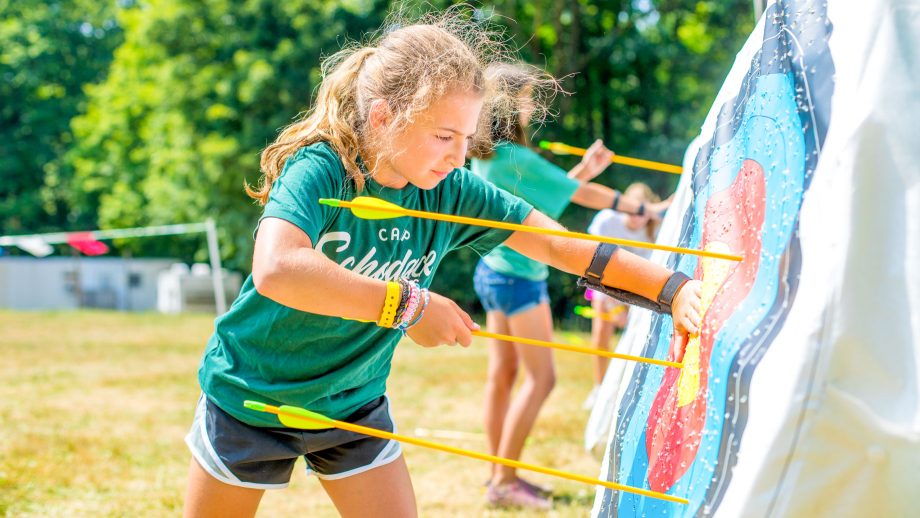 Girl retrieves arrows during summer camp archery