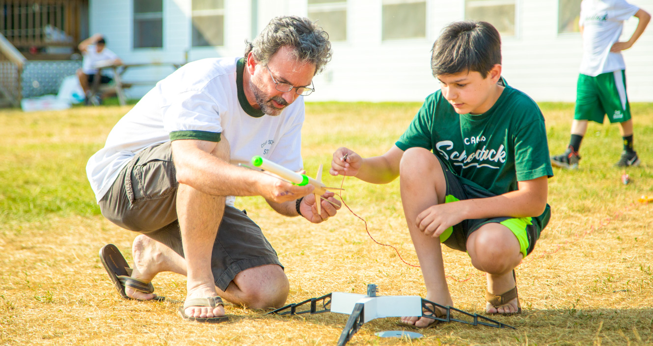 Staff member and camper prepare a rocket launch