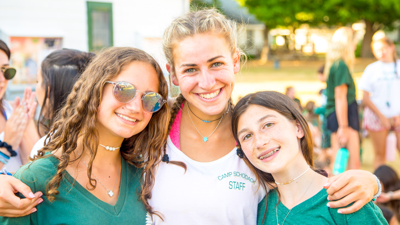 Smiling girls pose with summer camp counselor