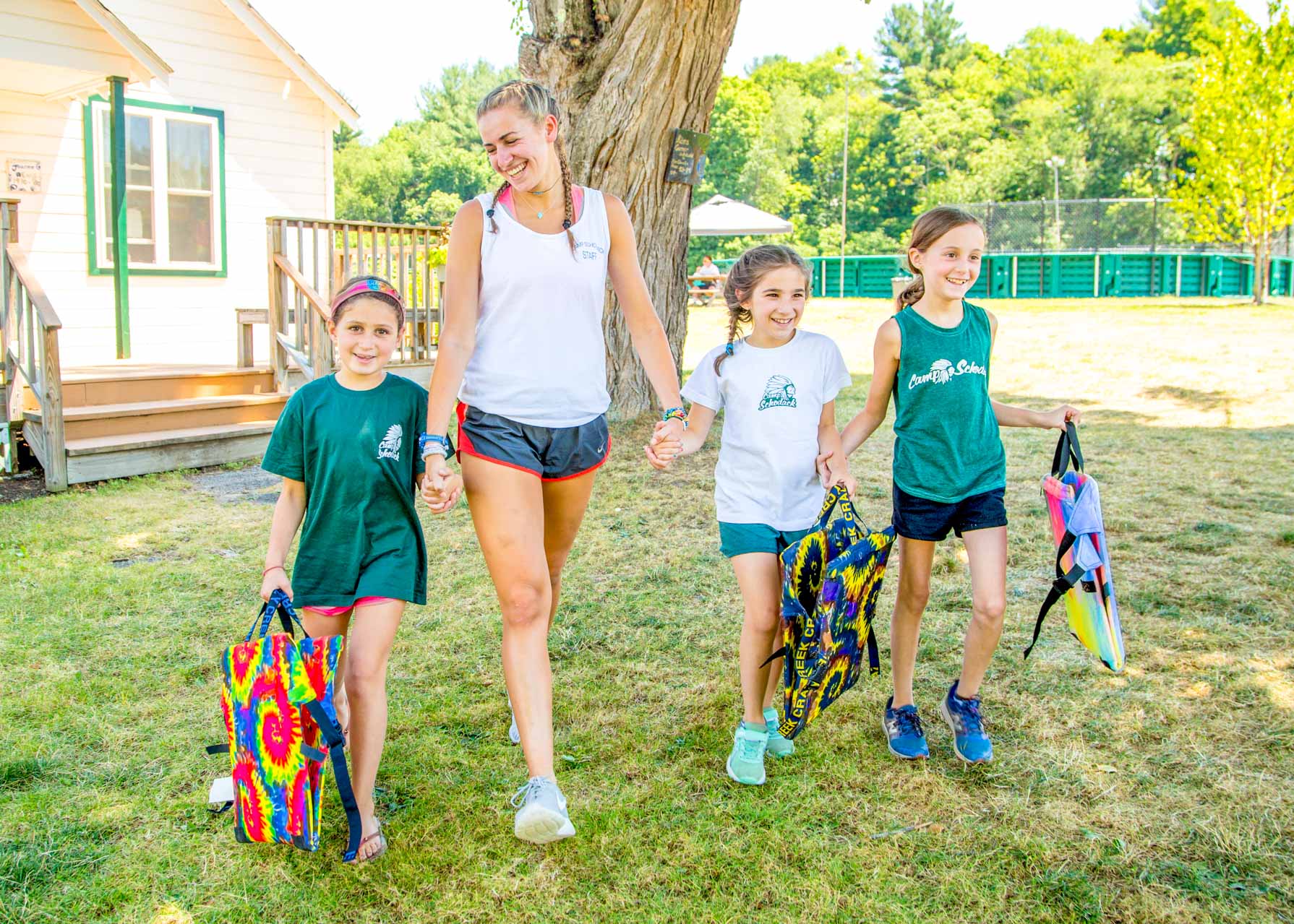 Staff member walks alongside three young campers