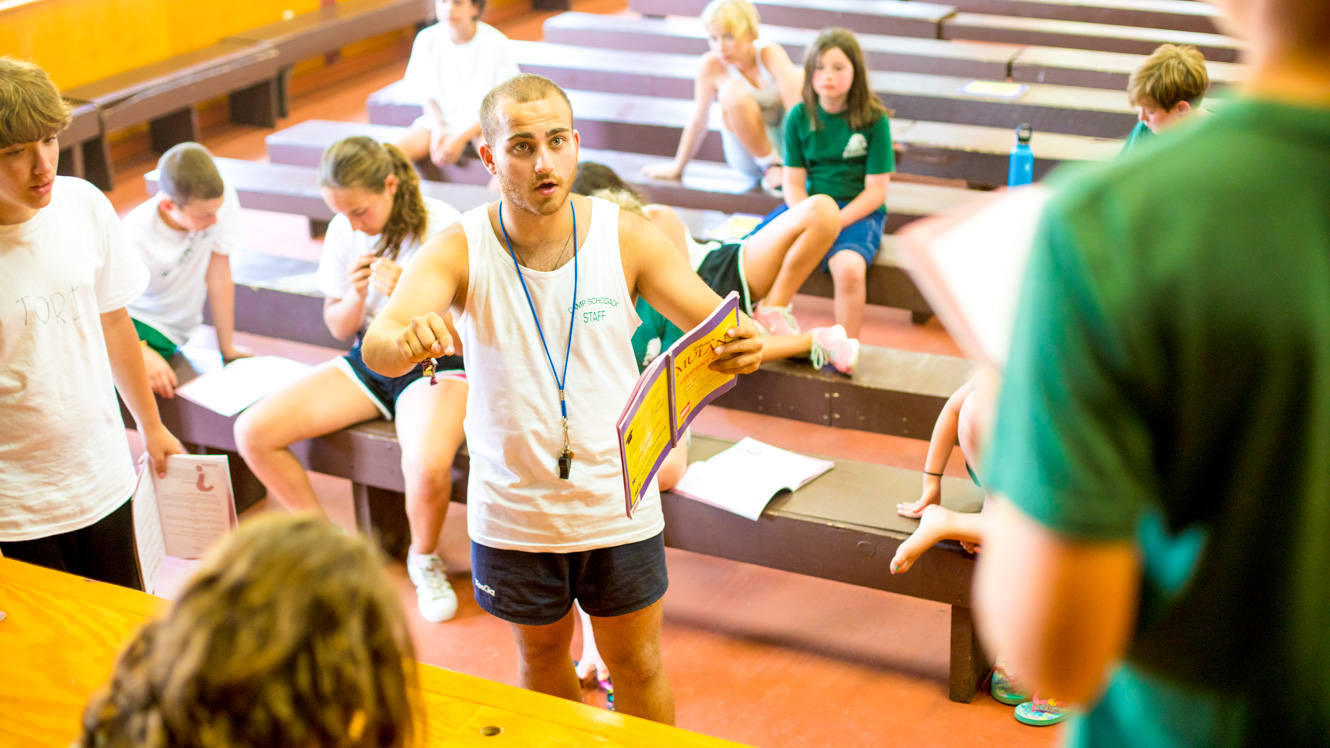 Staff member directs campers rehearsing for play