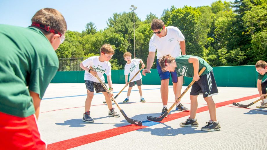 Camp staff member drops puck to begin street hockey game