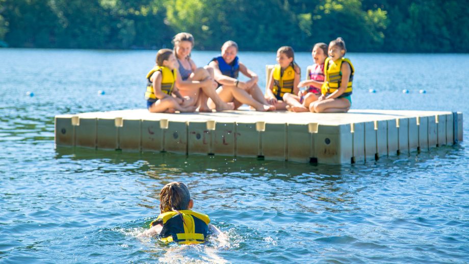 Camper swims out to meet others on floating dock