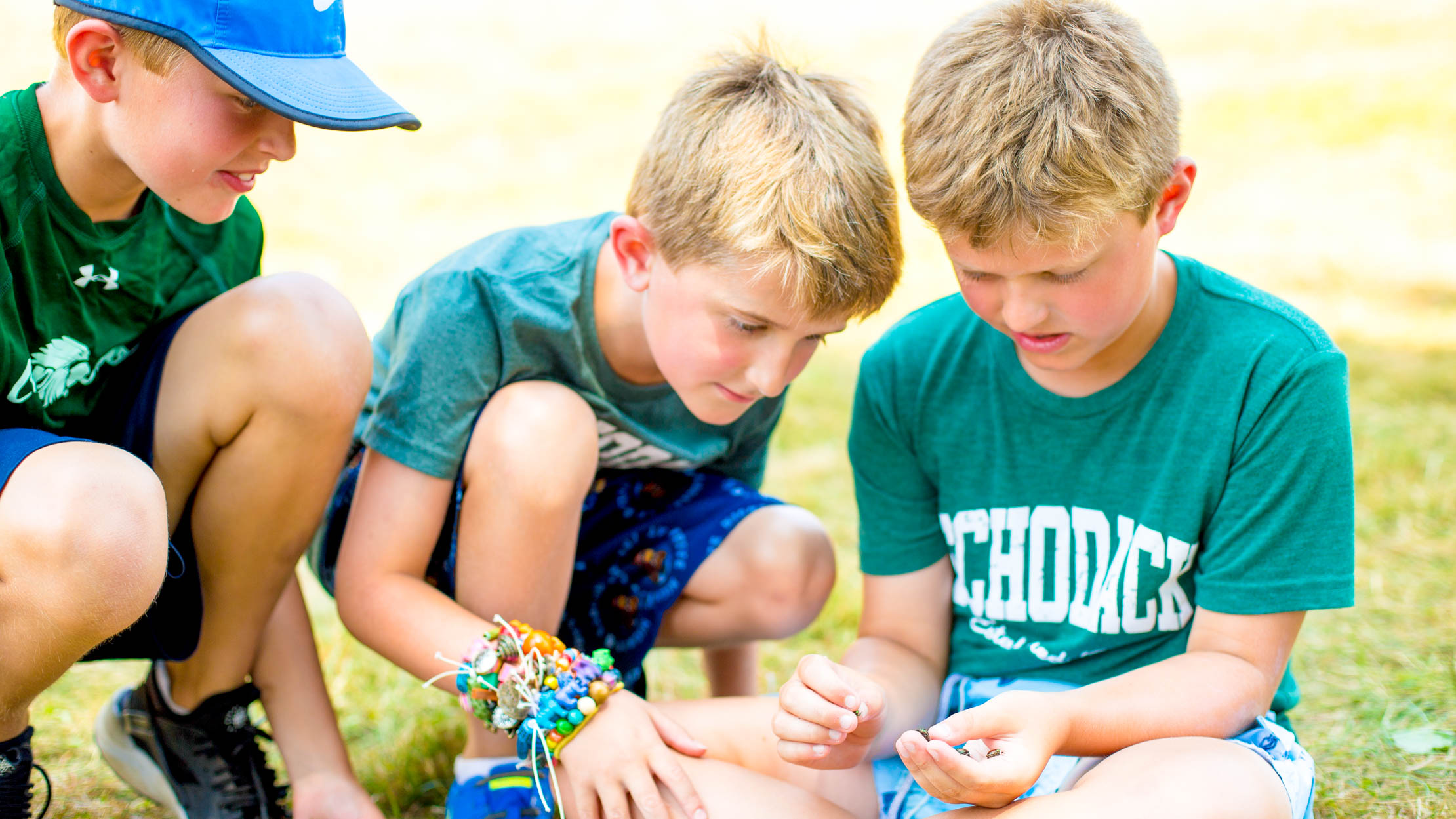 Boys gather to look at something