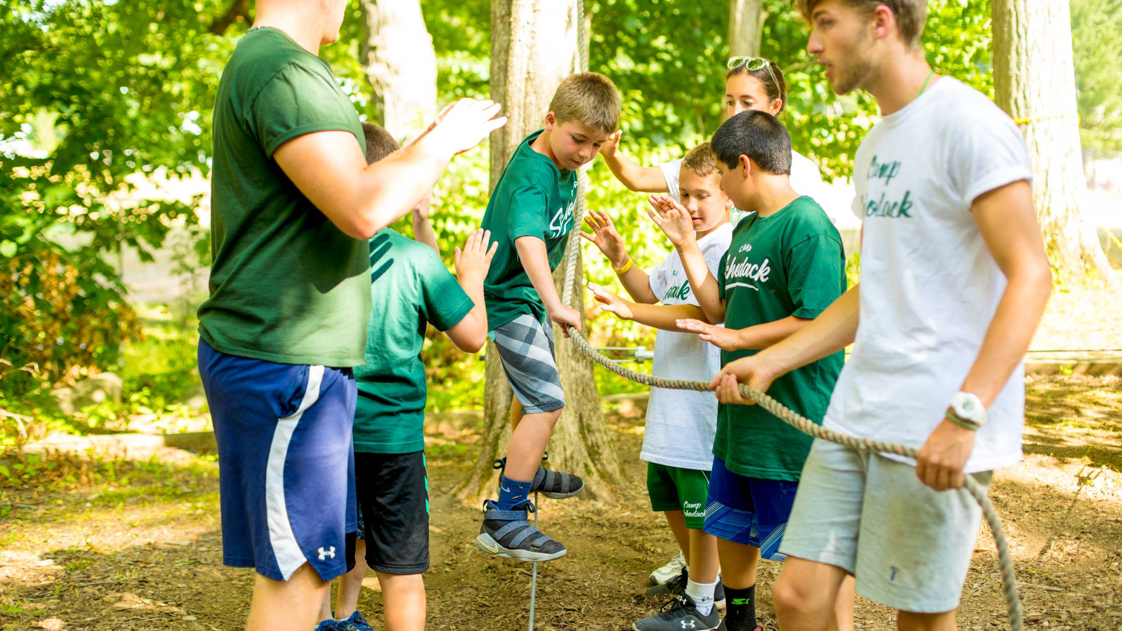 Boys cross low ropes course at summer camp