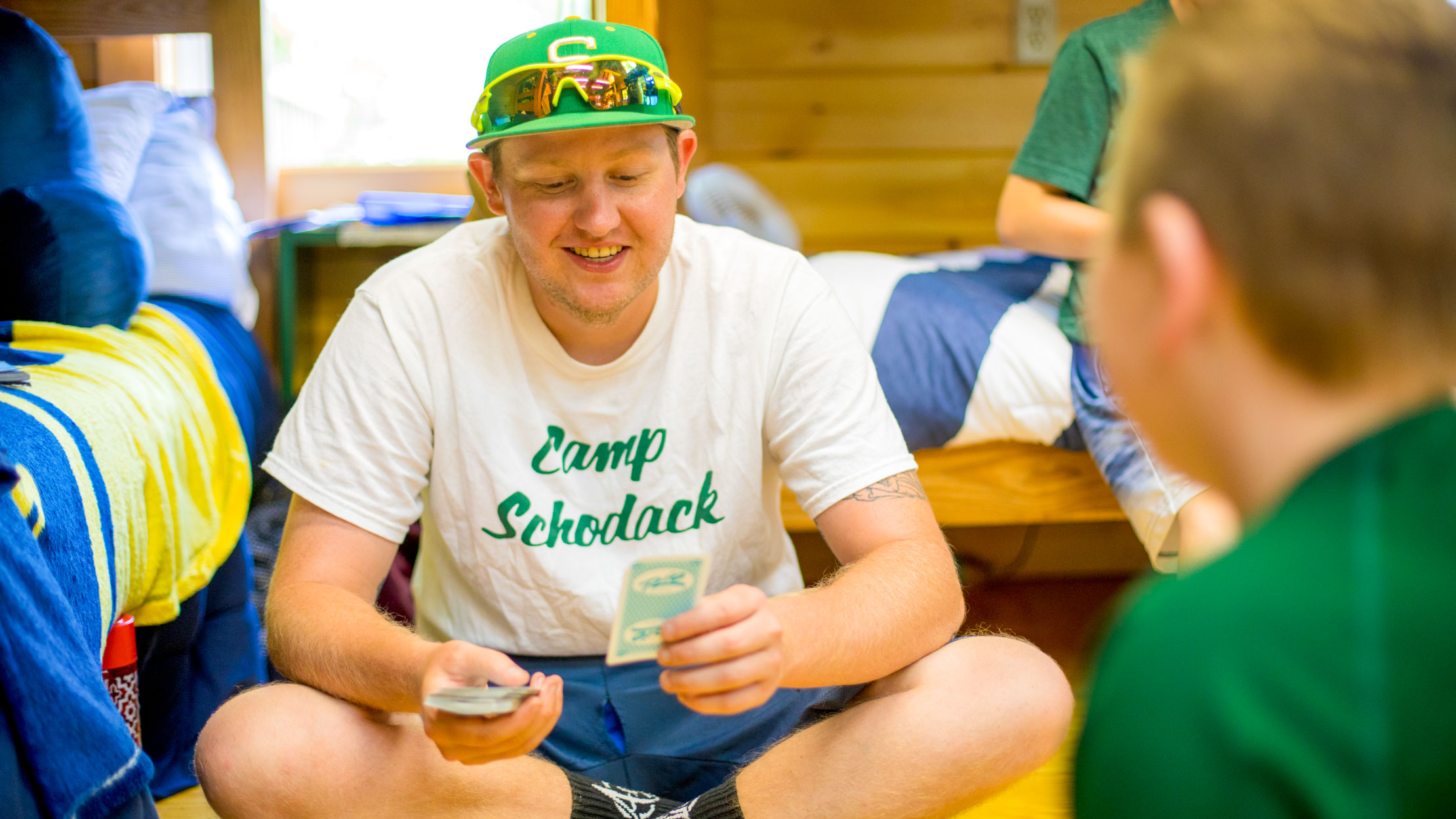 Counselor playing cards with campers in cabin