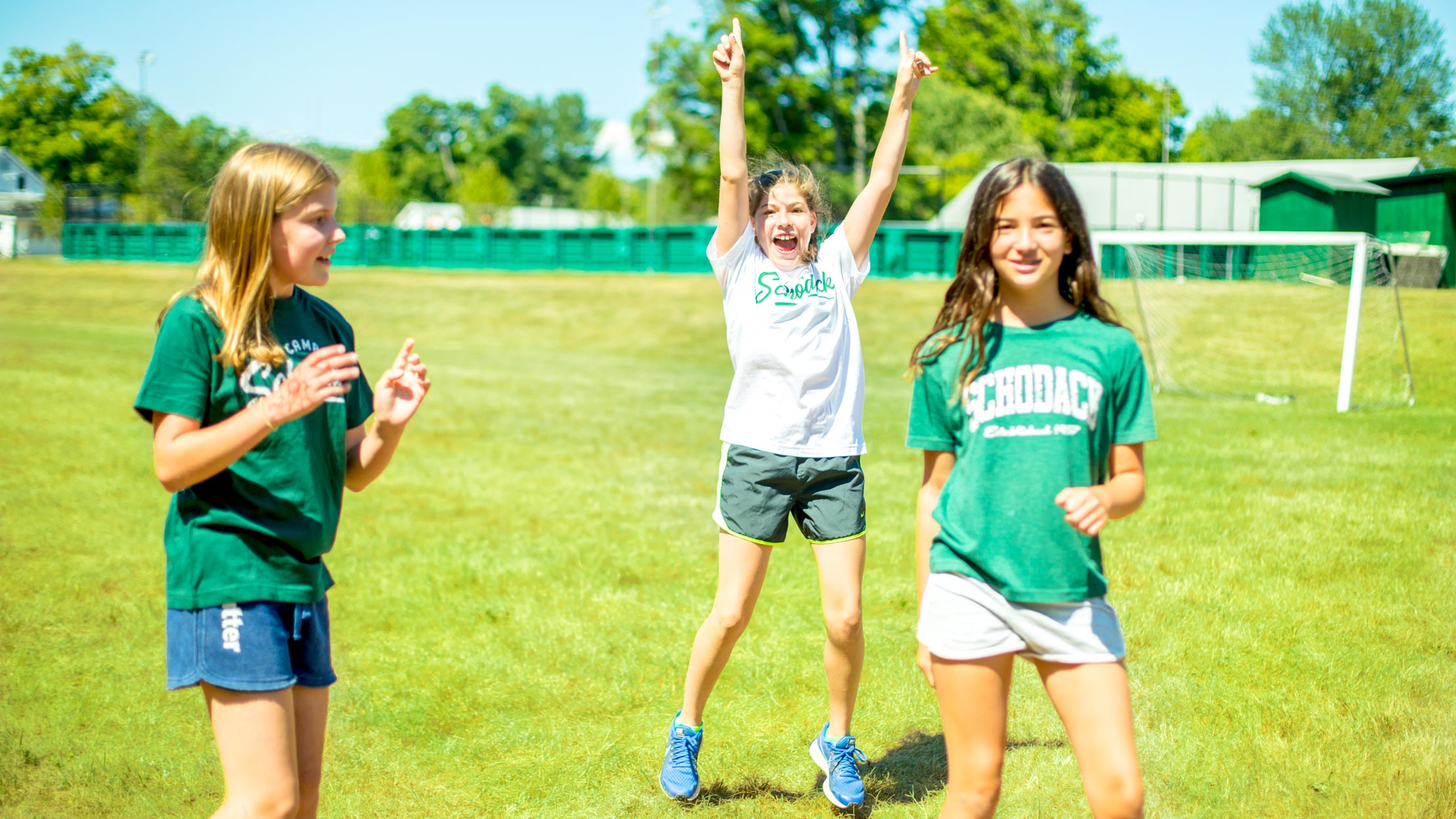 Girl cheers with arms up on soccer field