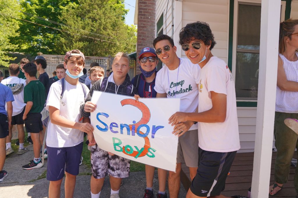 Staff and campers are holding up a sign that reads Senior 3 boys