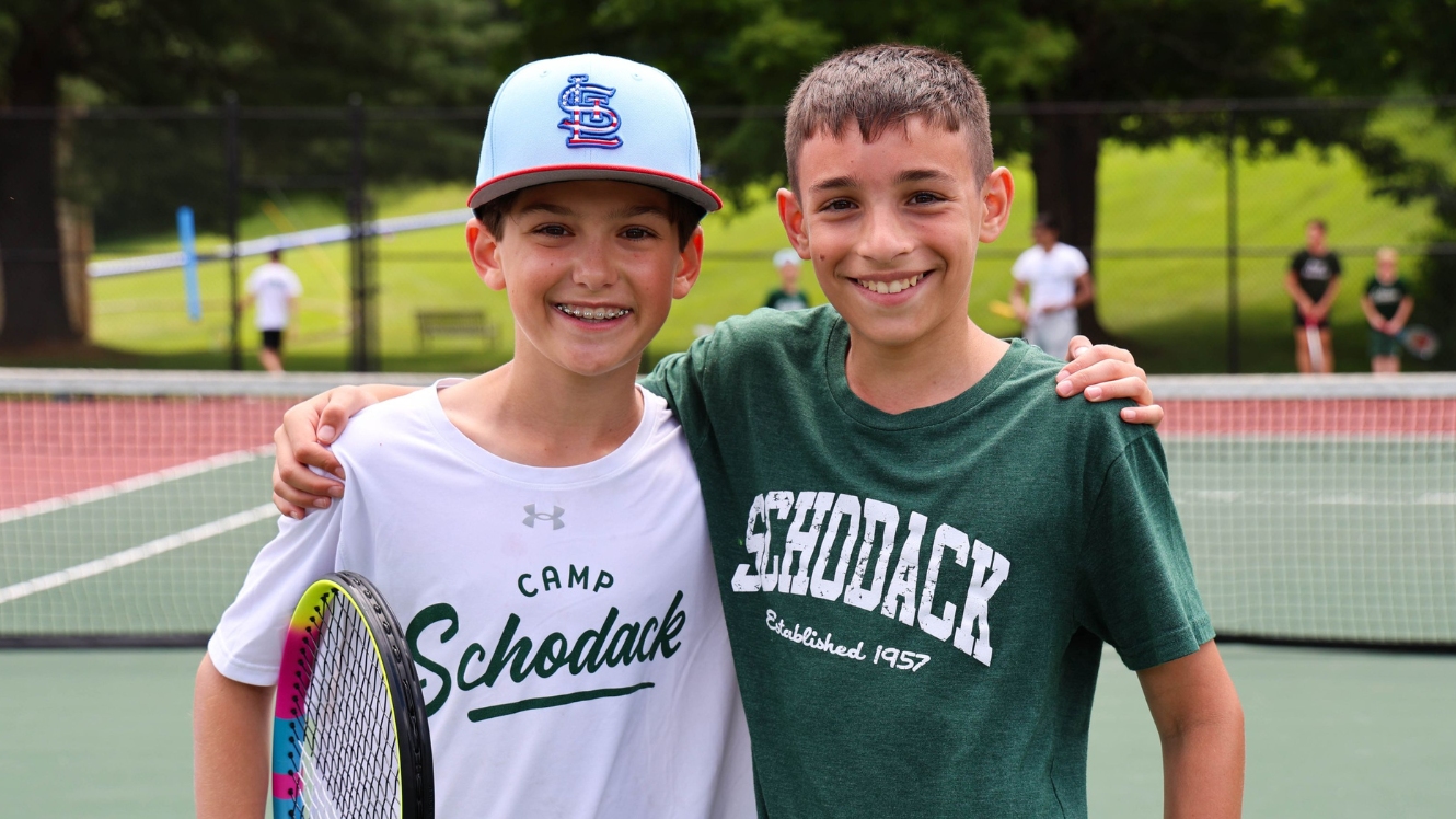Counselor shakes hands with camper